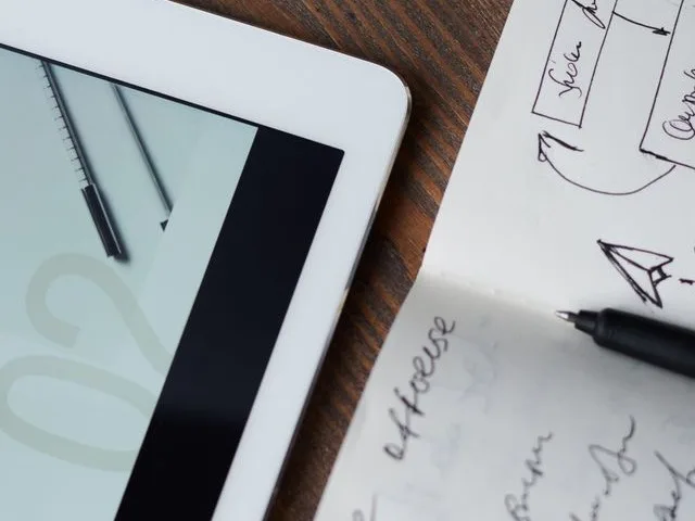Webfejlesztő UI-tervet és wireframe-et egyeztet a monitoron megjelenő makett alapján